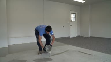 Dalinghaus Foundation Repair technician applying an epoxy coating to a garage concrete floor, part of concrete crack repair