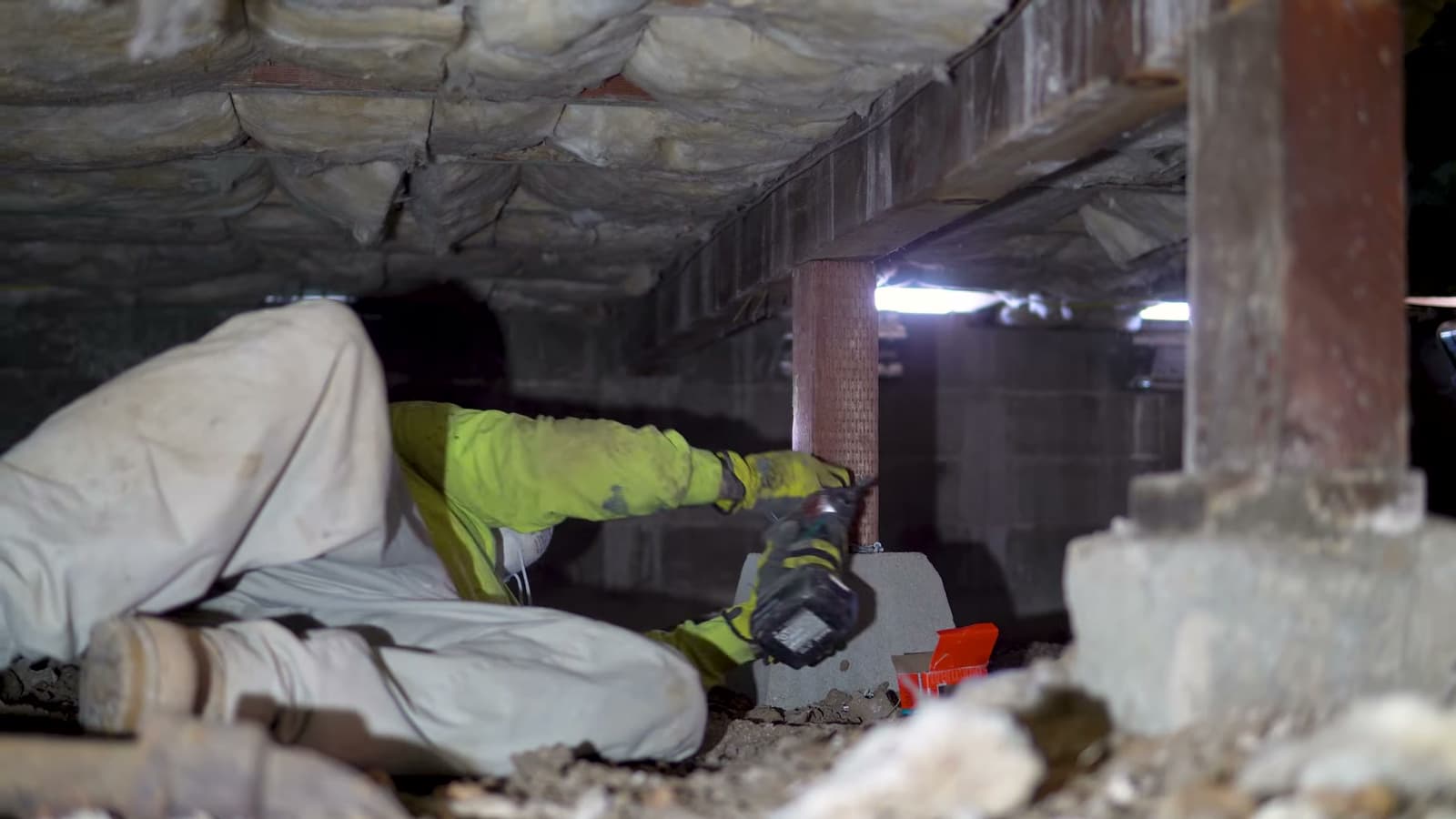 Dalinghaus Foundation Repair technician adjusting adjustable smart jacks to repair a sagging floor in a crawl space.