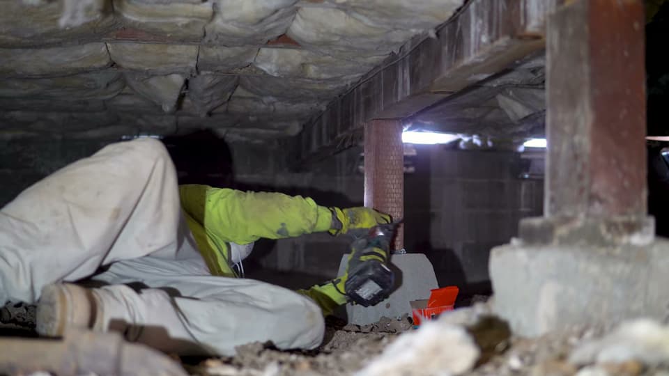 Dalinghaus Foundation Repair technician adjusting adjustable smart jacks to repair a sagging floor in a crawl space.