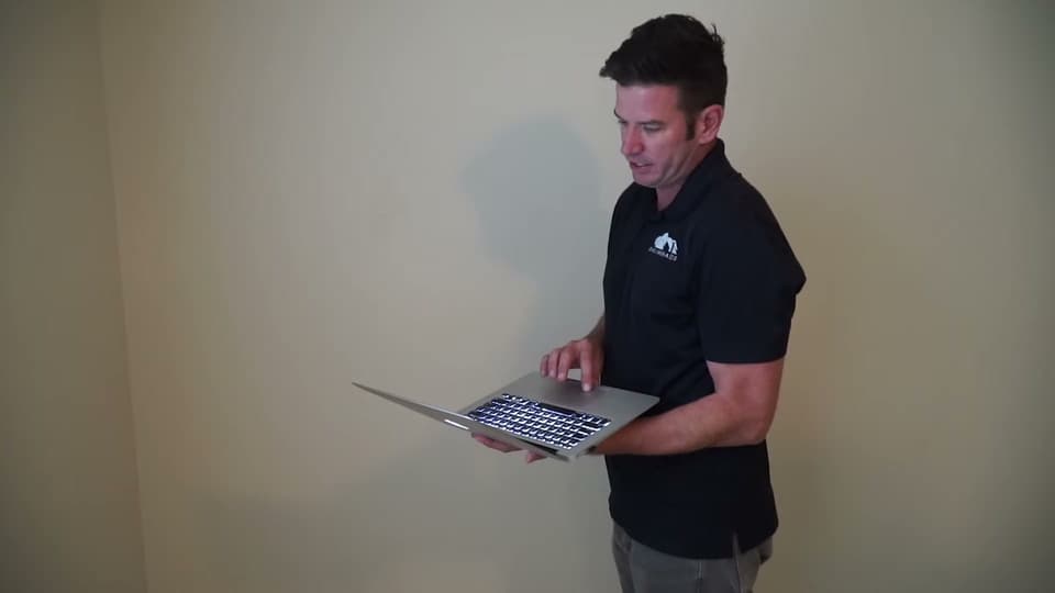 Dalinghaus Foundation Repair company representative using a laptop during a foundation inspection and consultation.