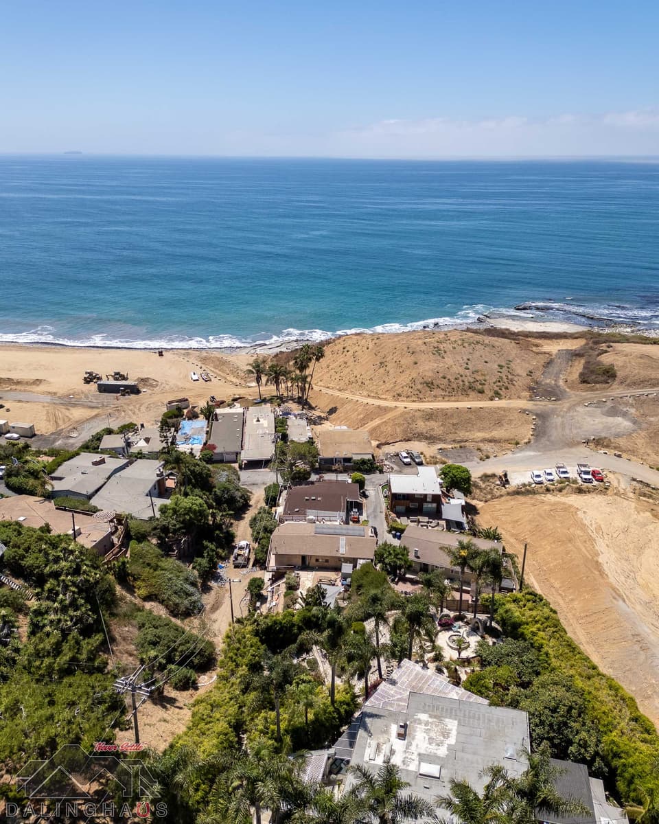 Aerial of the coastal neighborhood in Rancho Palos Verdes, the ocean beyond and freshly graded dirt lots to the right